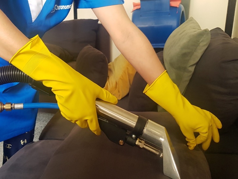 Intervenante Chronomenage nettoyant un canap&eacute; en tissu &agrave; l'injection-extraction